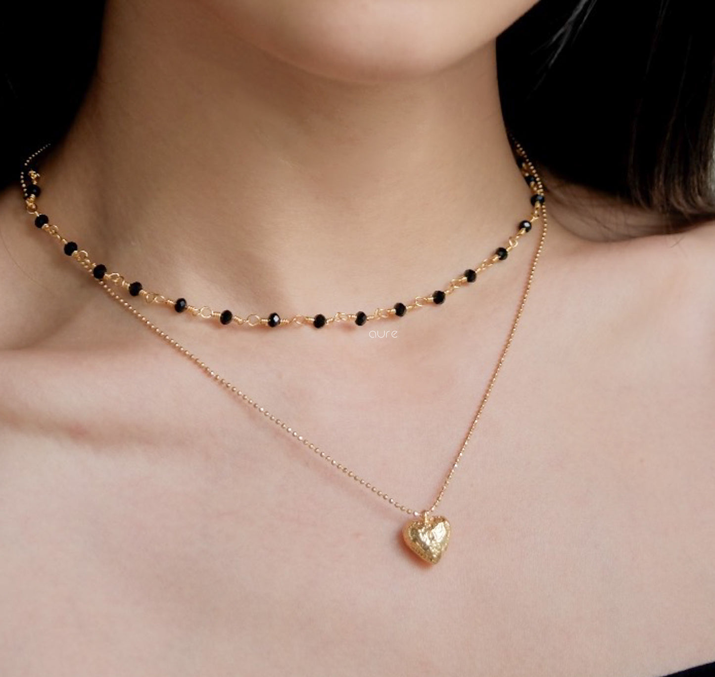 gold heart necklace on model